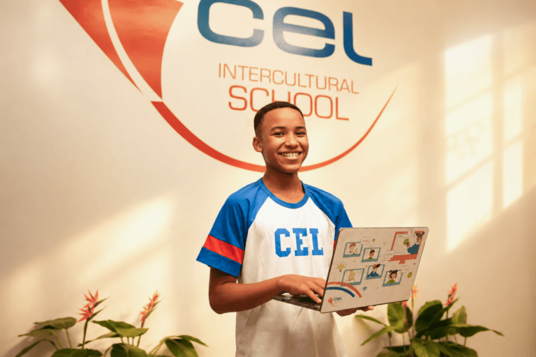 Aluno do Colégio CEL utiliza notebook em ambiente escolar, representando a campanha de indicação e a experiência de fazer parte da comunidade CEL.